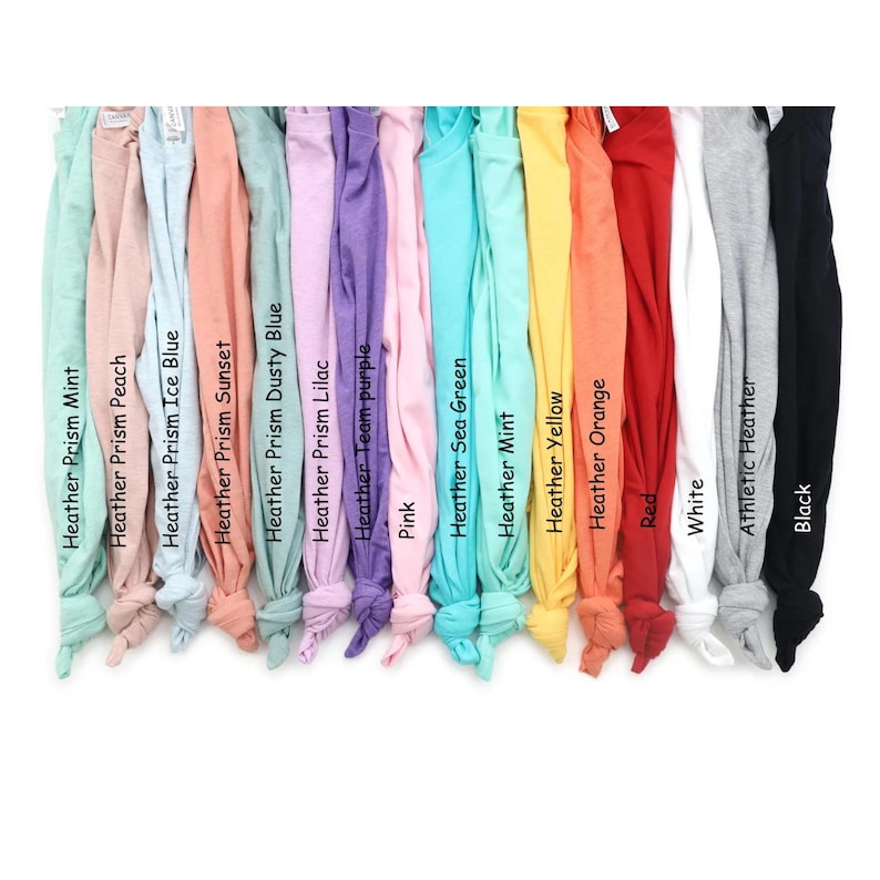 Pu&ograve; includere: Una collezione di quindici magliette disposte fianco a fianco in uno spettro di colori che include Heather Prism Mint, Peach, Ice Blue, Sunset, Dusty Blue, Lilac, Team Purple, Pink, Sea Green, Mint, Yellow, Orange, Red, White, Athletic Heather e Black.