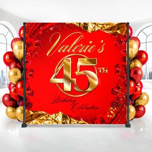 May include: A red backdrop for a 45th birthday celebration, featuring gold text that reads "Valerie's" and "45th Birthday Celebration." The backdrop is decorated with roses and gold accents, with red and gold balloons on either side.