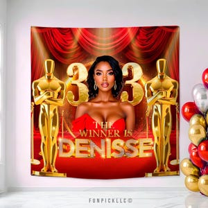 May include: A red and gold backdrop with the text "THE WINNER IS DENISSE" in gold lettering. The backdrop features a woman in a red dress, gold Oscar statues, and a red carpet design. Balloons are visible on the right.