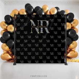 May include: A black backdrop with a gold glitter pattern and the letters "NR" repeated throughout. The letters "NR" are larger in the center of the backdrop with the name "NIA ROBINSON" in gold glitter letters.
