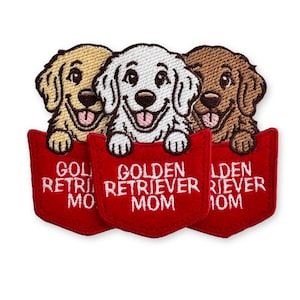 May include: Three embroidered patches featuring golden retriever puppies in shades of tan, white, and brown. Each puppy is peeking out of a red pocket with the white embroidered text GOLDEN RETRIEVER MOM visible on the front of each pocket.