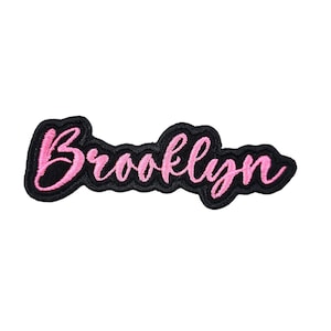 May include: Pink embroidered "Brooklyn" text on a black fabric patch.