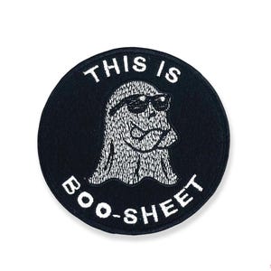 May include: Black and white embroidered patch with a ghost wearing sunglasses and the text "This is Boo-Sheet".