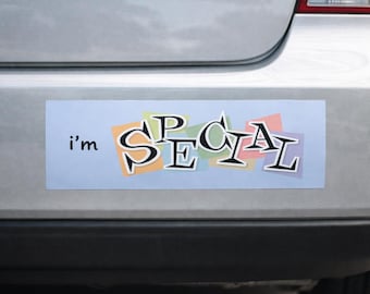 May include: A rectangular bumper sticker with the words "i'm SPECIAL" in a playful font. The text is in black with a white outline, set against a light blue background with colorful square accents.