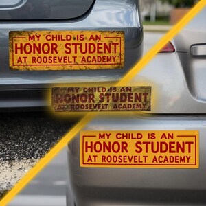 May include: A yellow bumper sticker with red text stating "MY CHILD IS AN HONOR STUDENT AT ROOSEVELT ACADEMY." The rectangular sticker has a red border. The image shows the sticker attached to the rear of a grey car.