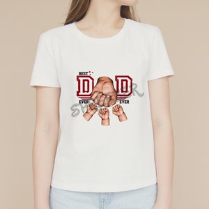 May include: White t-shirt with a red graphic that says "Best Dad Ever" with a fist and smaller hands around it.
