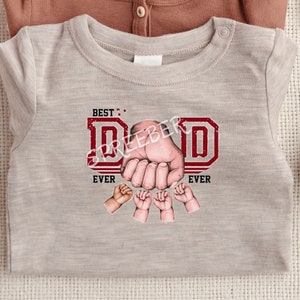 May include: A light gray t-shirt with a red graphic that says "BEST: DAD EVER" with a hand and small hands around the letters.