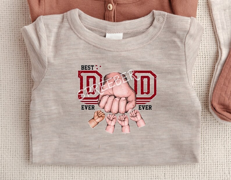May include: A light gray t-shirt with a red graphic that says "BEST: DAD EVER" with a hand and small hands around the letters.