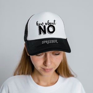 May include: A black and white trucker hat with the text "how about NO" in black lettering. The hat has a black mesh back and a white front.