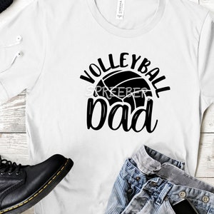 May include: White t-shirt with black text that reads "Volleyball Dad" and a volleyball graphic.
