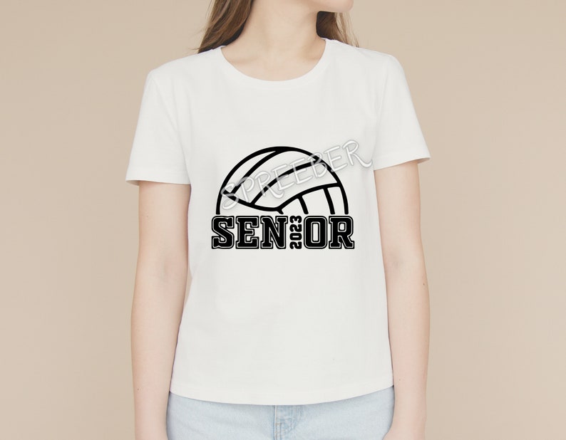 May include: White t-shirt with a black volleyball graphic and the text "SENIOR 2023"