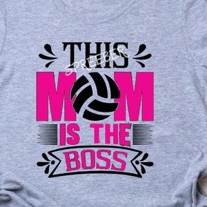 May include: Gray t-shirt with the text "This Mom is the Boss" in black and pink. A volleyball graphic is in the center of the text.