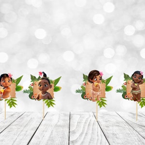 May include: Four cupcake toppers featuring a cartoon baby with brown skin, brown hair, and a flower in their hair. Each topper is set against a green leafy background with a brown sign.