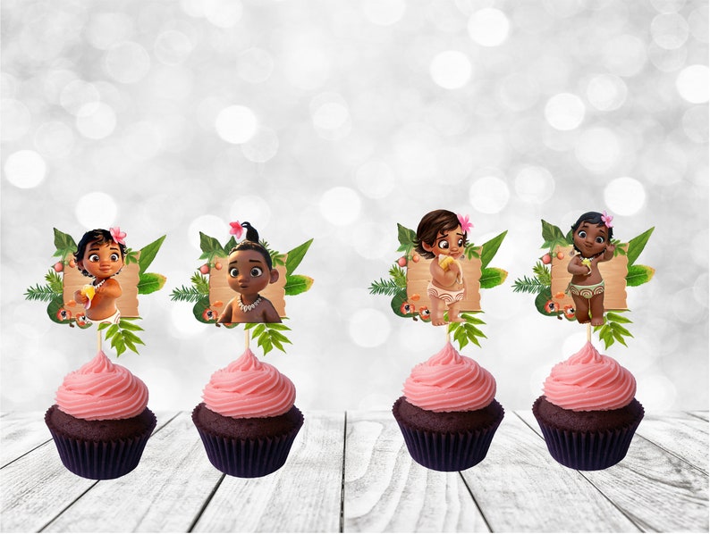 May include: Four cupcakes with pink frosting and brown cupcake liners. Each cupcake has a Moana themed topper with a cartoon image of a baby Moana in a tropical setting.