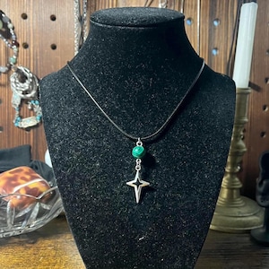 handmade y2k black fabric cord necklace with green and black swirl bead and sparkly star pendant