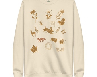May include: A cream-colored sweatshirt with a pattern of various animals and plants in shades of brown and gold. The design includes a rabbit, a squirrel, a fox, a deer, a bird, a snake, a ladybug, a flower, and a sun.