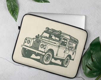 May include: A beige laptop sleeve with a green line drawing of a vintage Land Rover with a roof rack and spotlights.