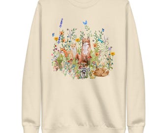 May include: A cream-colored sweatshirt with a watercolor illustration of foxes and other woodland creatures surrounded by flowers and butterflies.