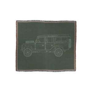 May include: A green throw blanket featuring a white outline of a Land Rover Defender.