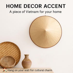 Pode incluir: Uma cole&ccedil;&atilde;o de artigos de decora&ccedil;&atilde;o para casa, incluindo um chap&eacute;u c&oacute;nico tecido, um cesto redondo tecido, uma tigela pequena tecida e um vaso de cer&acirc;mica. O chap&eacute;u est&aacute; pendurado na parede. O texto diz: "HOME DECOR ACCENT, A piece of Vietnam for your home, Hang on your wall for cultural charm."