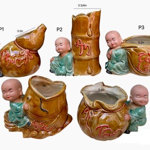 May include: Five ceramic planters featuring a small, smiling, cartoon-like person holding a larger ceramic pot. The pots are decorated with Chinese characters and are in various shapes, including a gourd, a bamboo stalk, and a bag. The planters are 9.5 cm, 8.1 cm, 13.2 cm, 10.2 cm, and 13.7 cm tall.
