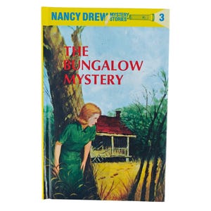 May include: A vintage book cover for "The Bungalow Mystery" by Nancy Drew. The cover features a woman in a green dress, a red-roofed bungalow, and the title in red letters. The book is number 3 in the series.