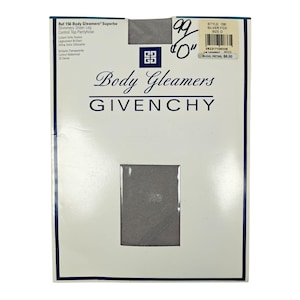 May include: A package of Givenchy Body Gleamers pantyhose in Silver Fox. The package has a white background with the brand name and product details printed in black and blue. The pantyhose are visible through a rectangular window.