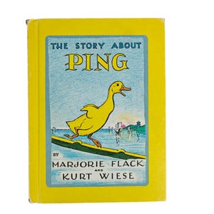 May include: A vintage children's book titled "The Story About Ping" by Marjorie Flack and Kurt Wiese. The cover is yellow with a blue border, featuring a yellow duck illustration. The book's title is in large, bold letters.
