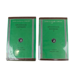 Puede incluir: Dos libros antiguos de la serie Loeb Classical Library. Los libros tienen cubiertas verdes con el título "Apostolic Fathers" y los números de volumen I y II. También es visible el texto "Translated by Kirsop Lake".