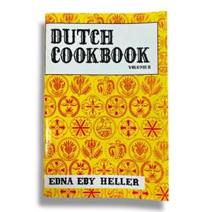 May include: A yellow cookbook with a red and white pattern on the cover. The title is "Dutch Cookbook" with the words "Volume II" below. The author's name is "Edna Eby Heller" at the bottom.