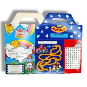 May include: A blue and red Wendy's Kids' Meal box with a star-spangled design. The box features a maze, a word search, and a map of the United States. The box also includes the text "Wendy's Kids' Meal" and "Prize Inside".