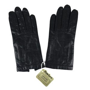 Puede incluir: Un par de guantes de cuero negro con detalles cosidos. Los guantes tienen una etiqueta que dice "Fownes EST 1777 GENUINE LEATHER THE GLOVE PEOPLE". Estos guantes son probablemente para el frío o la moda.