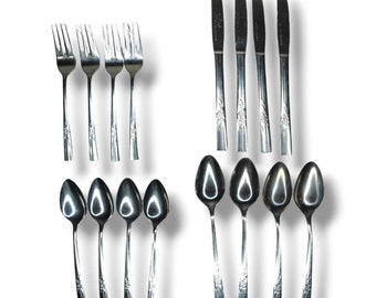 May include: A set of silverware with a floral design. The set includes forks, knives, and spoons.