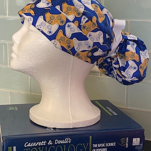 Gold and White Game Controllers on Blue | Scrub Cap | Surgical Hat | Women’s Styles: Ponytail, Pixie, Bouffant | Doctor and Nurse Gifts