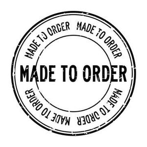 May include: A black, circular rubber stamp with the words "MADE TO ORDER" in bold, centered text. The phrase "MADE TO ORDER" is also repeated around the outer edge of the stamp in a circular pattern. The stamp has a worn, grunge-like texture.