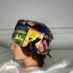 May include: A colorful scrub cap featuring various book covers from the Harry Potter series. The cap displays images of Harry Potter, with titles like "Deathly Hallows" and "Chamber of Secrets". The cap is tied at the back.