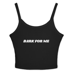 May include: Black crop top with thin straps. The words "BARK FOR ME" are printed in white across the front. The top is made of a soft material and is designed to be form-fitting.