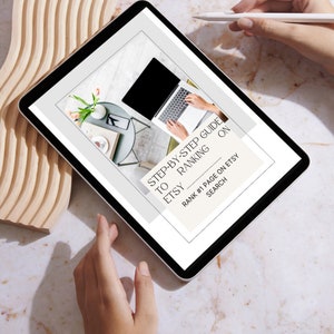 May include: A digital tablet displaying a guide on how to rank Etsy listings on the first page of search results. The guide is titled "Step-by-Step Guide to Etsy Ranking on Search".