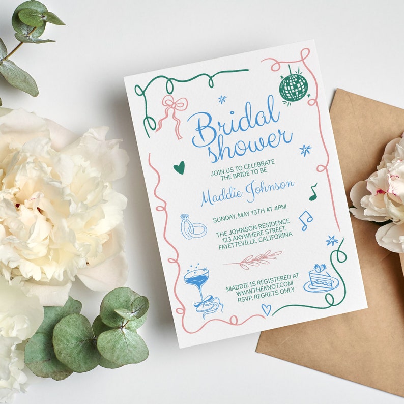 May include: A white bridal shower invitation with pink and green doodle accents. The invitation features the text "Bridal Shower" and the bride-to-be's name, "Maddie Johnson". The invitation also includes the date, time, and location of the shower, as well as the bride's registry information.