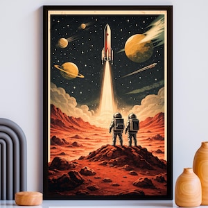 May include: A framed art print depicting a retro space scene. Two astronauts stand on a red planet, watching a rocket launch into a starry sky. Planets and celestial bodies are visible. The artwork has a vintage, comic book style.