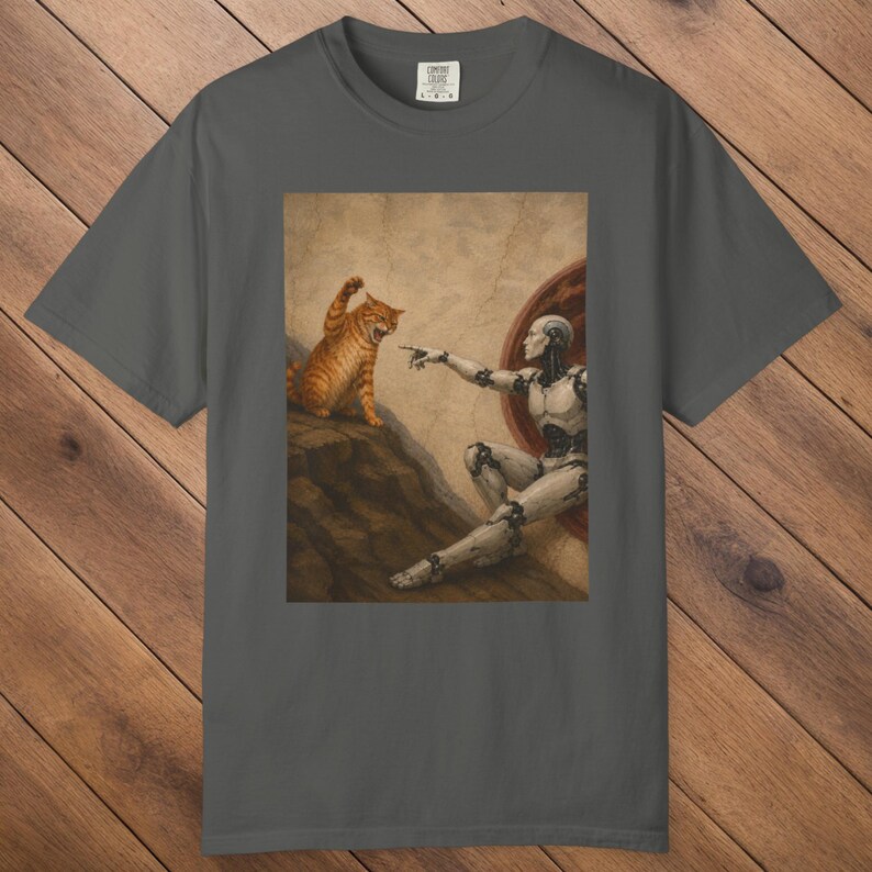 May include: Dark gray t-shirt featuring a parody of the Sistine Chapel painting. The image depicts a robot reaching towards an orange tabby cat. The cat is in a defensive posture, with its paw raised.