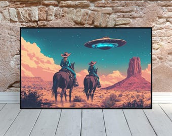 May include: A framed art print depicts two figures on horseback in a desert landscape, gazing at a UFO. The artwork features a vibrant color palette of blues, oranges, and browns, with a large rock formation in the background. The print is displayed on a white wooden surface.