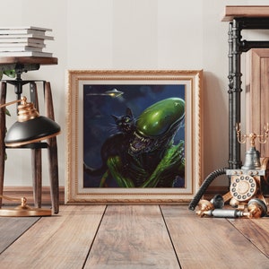 May include: A framed print of a green alien creature with a black cat. The alien has a large head and is holding the cat in its arms. The background is a dark blue with stars. The print is in a gold frame.