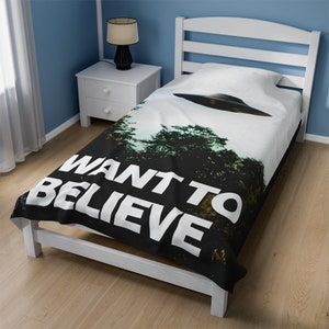 May include: Black and white bedding with a UFO flying over a forest. The text "WANT TO BELIEVE" is printed in white on the bedding.