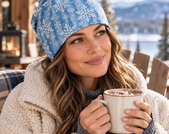 May include: A light blue beanie featuring a white snowflake pattern and vertical stripes. The hat is made of fabric and has a soft, rounded shape that fits snugly on the head, displaying a winter-themed design with white and gold accents.