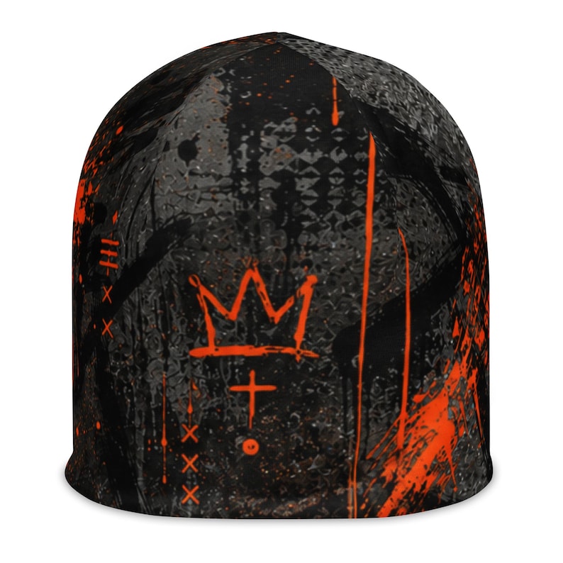 Black and orange grunge beanie with distressed graffiti print, abstract textures, paint splatter and bold orange crown graphic, unisex alternative streetwear hat.