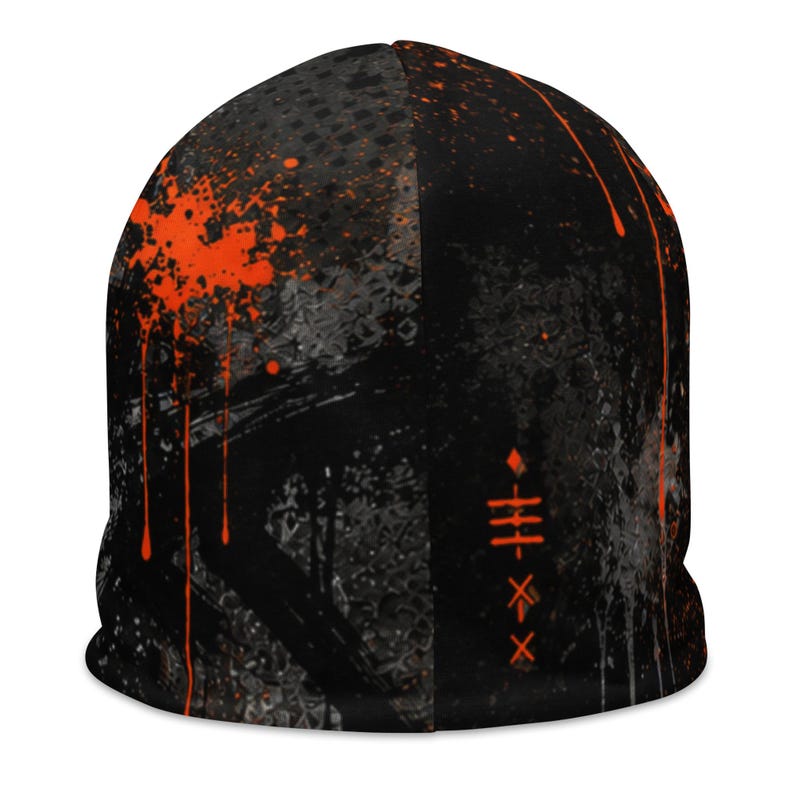 Back view of black grunge beanie featuring charcoal distressed textures, orange paint splatter and abstract graffiti markings, edgy unisex streetwear accessory.