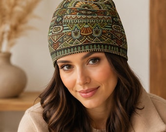May include: A beanie hat featuring a repeating geometric pattern in shades of olive green, brown, tan, and cream. The design consists of horizontal bands filled with intricate shapes, including semicircles, triangles, and lines, covering the entire surface.