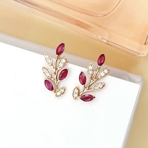 Örhängen med naturliga rubiner: Design med pilkvist i 18k roséguld