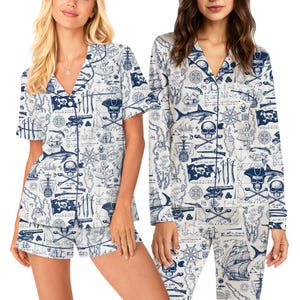 Könnte beinhalten: Weißes Pyjama-Set mit einem marineblauen Piratenkarten-Design. Das Set beinhaltet ein kurzärmeliges Hemd mit Knöpfen und Shorts. Ein langärmeliges Pyjama-Set mit dem gleichen Design ist ebenfalls abgebildet.